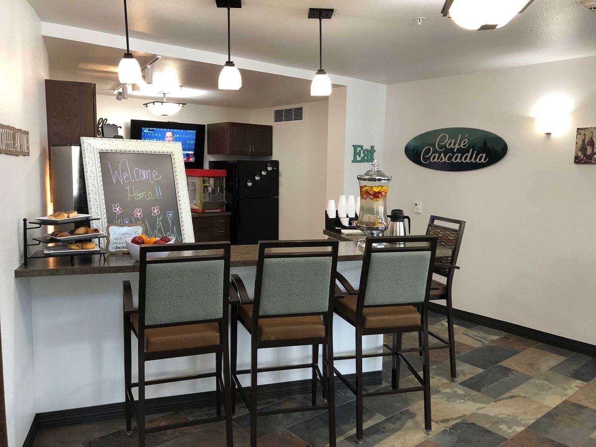 A cozy cafe bar area with a counter and high chairs.