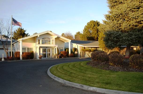 A suburban house with a curved driveway and well-maintained landscaping.