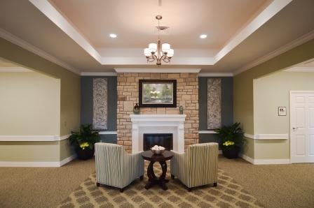 A cozy living room with a brick fireplace, two armchairs, and elegant decor.