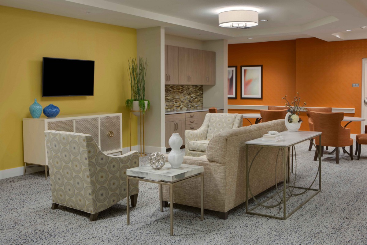A modern living room with colorful walls and stylish furniture, including a sofa, armchair, and coffee table.