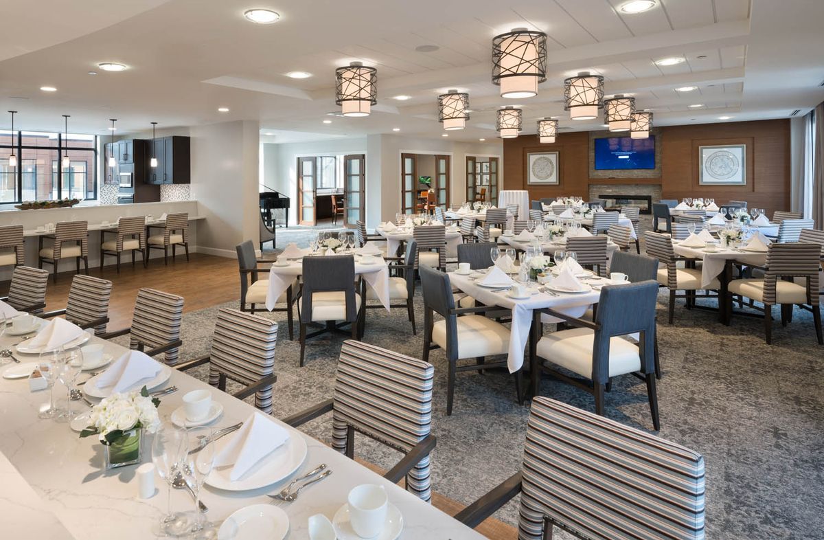 An elegant dining room with neatly arranged tables and chairs, soft lighting, and tasteful decor.