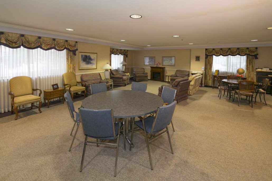 A spacious meeting room with a central table, surrounding chairs, and comfortable sofas.
