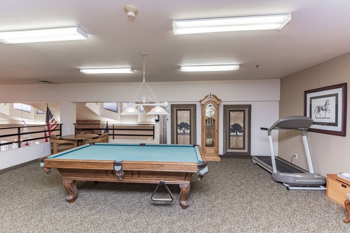 A game room featuring a billiard table, treadmill, and a grandfather clock.