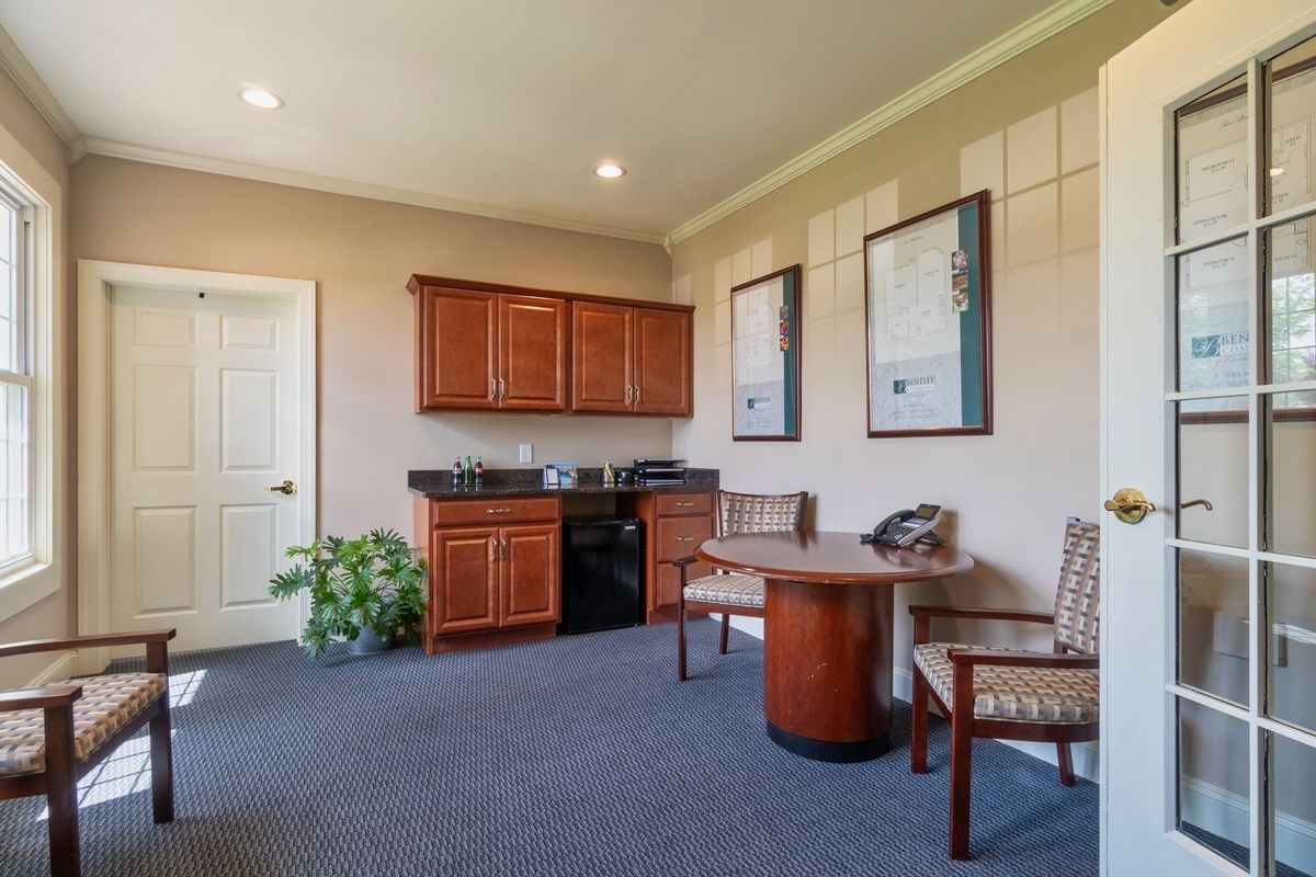 A small office space with a kitchenette and seating area.