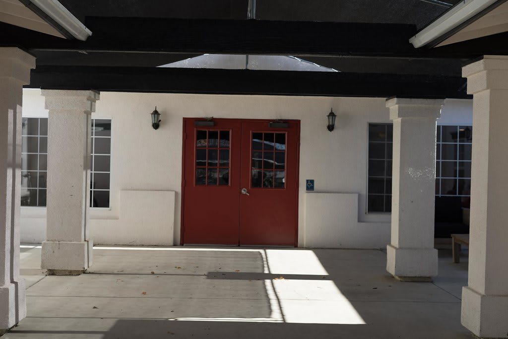 Entrance with red double doors and flanking windows.