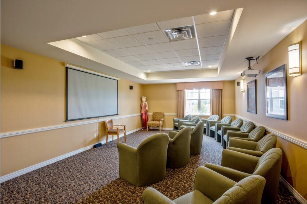 A conference room with comfortable seating and a projector screen.