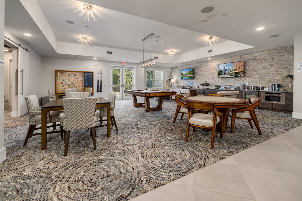 A modern living space with stylish furniture and decor, featuring dining tables and elegant lighting.