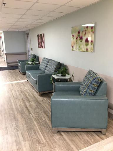 A cozy waiting area featuring modern upholstered chairs and decorative plants.
