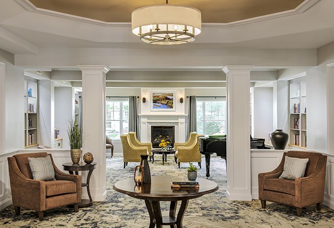 A cozy living room with elegant furniture and a central fireplace.