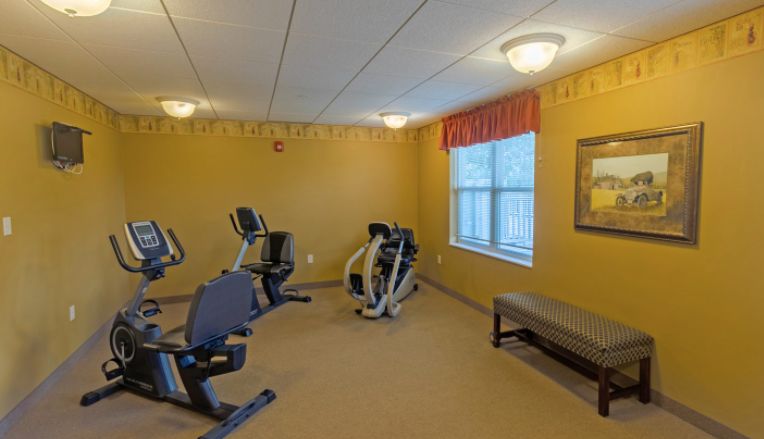 A small indoor gym with exercise equipment, including stationary bikes and an elliptical machine.