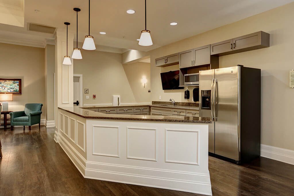 A modern kitchen with stainless steel appliances and pendant lighting.
