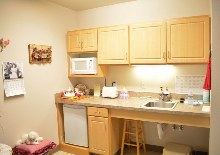 A compact kitchen with wooden cabinets, a microwave, and a sink area.