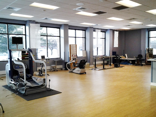 A spacious fitness studio equipped with various exercise machines and plenty of natural light.