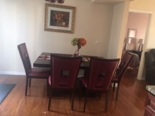 A cozy dining area with a table set for four, adorned with a decorative centerpiece and a painting on the wall.