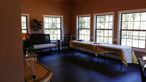 A bright, inviting interior space featuring multiple windows, a seating area, and a table.