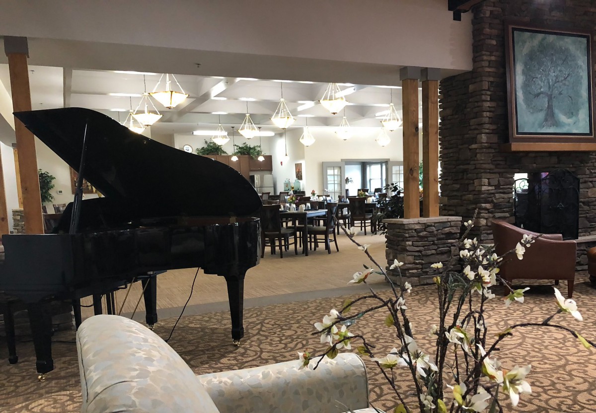 Elegant restaurant interior with a grand piano and floral decor.