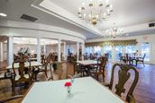 An elegant restaurant interior with chandeliers and neatly arranged tables.