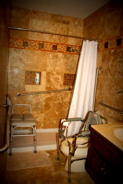 A wheelchair-accessible bathroom featuring a shower chair and grab bars, designed for ease of use.