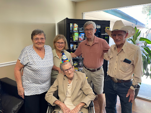 A joyful family gathering with an elderly member in a wheelchair.