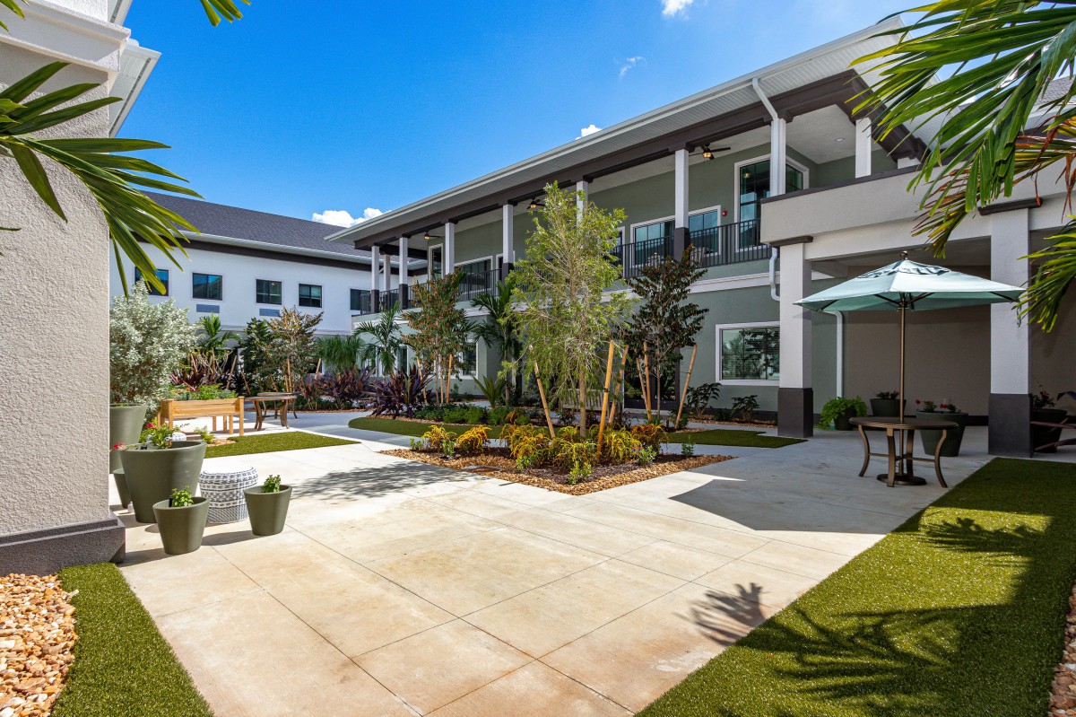 A beautifully landscaped courtyard surrounded by modern architecture on a sunny day.