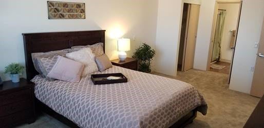 A cozy bedroom with a neatly made bed and warm lighting.