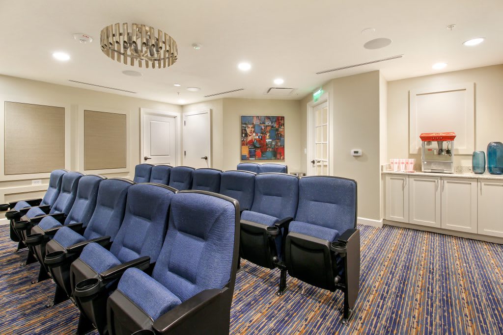 A cozy home theater room with rows of blue seating and modern decor.