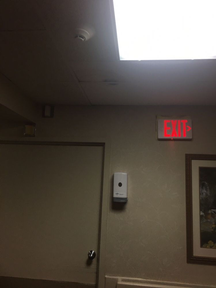 Interior view featuring an illuminated exit sign above a door.