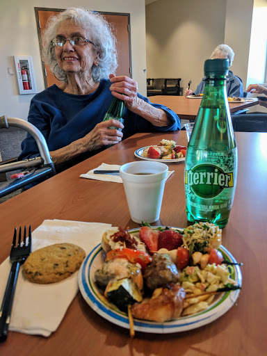 A delightful meal shared among friends, featuring colorful dishes and refreshing Perrier.
