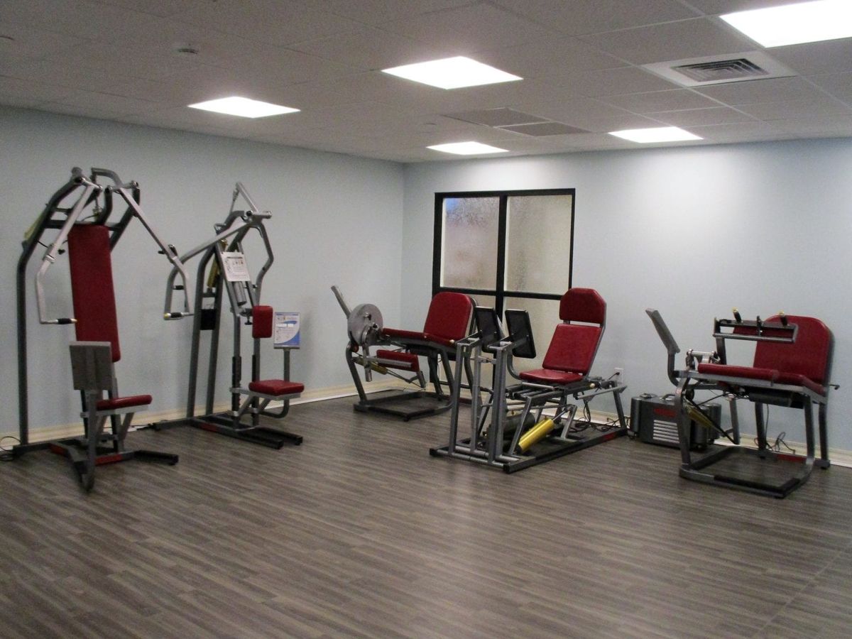A modern gym room with various exercise machines and equipment.