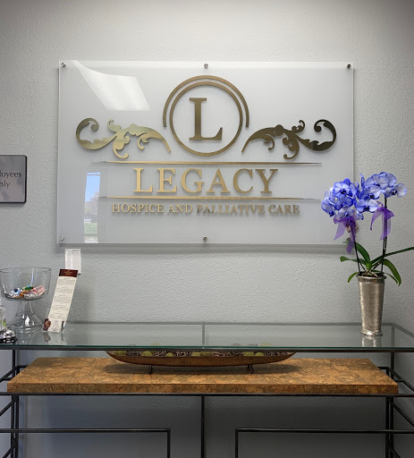 A sleek reception area featuring a decorative sign for 'Legacy' adorned with an elegant flower arrangement.