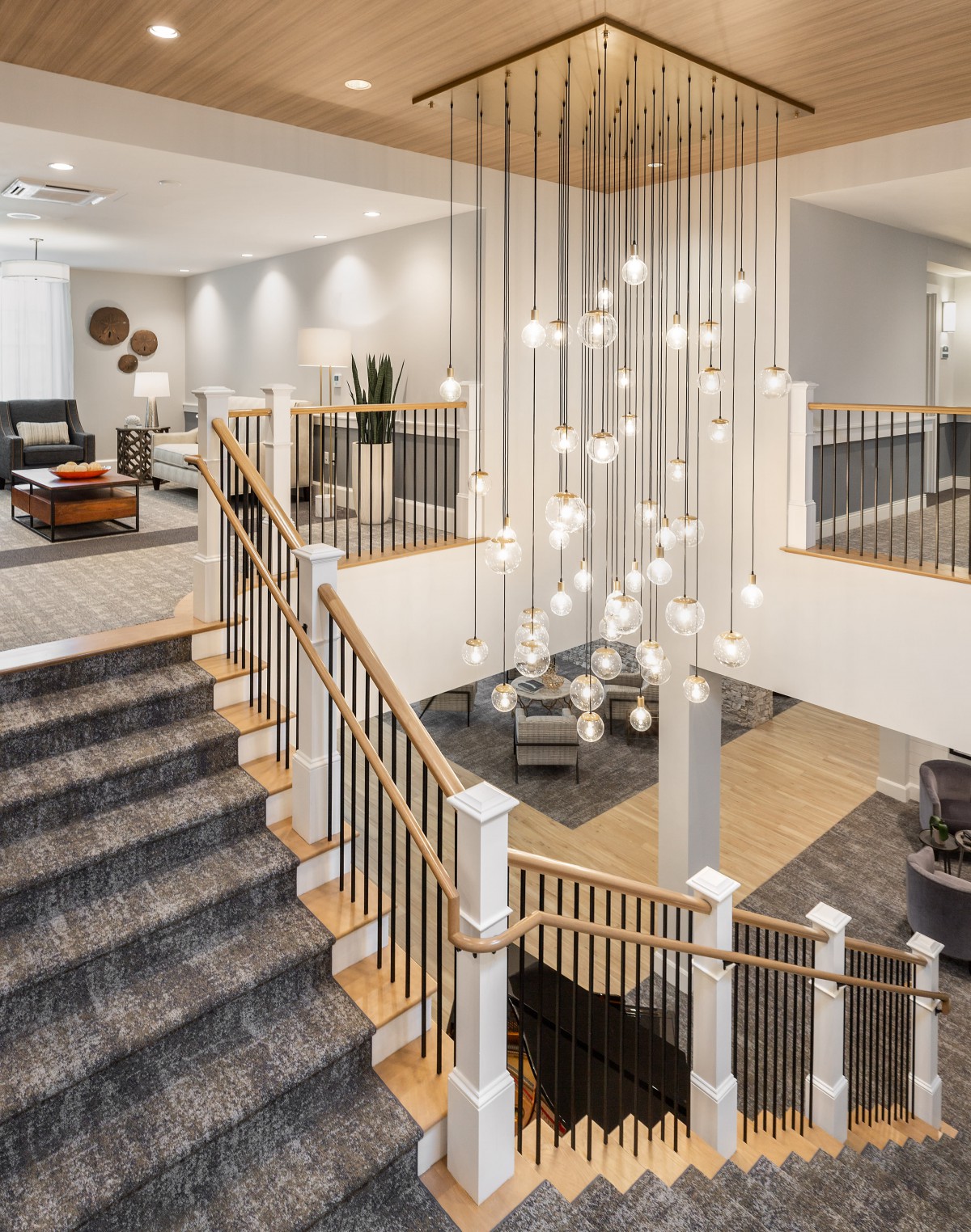 A modern two-story home interior featuring a stylish chandelier and an open living area with a grand staircase.