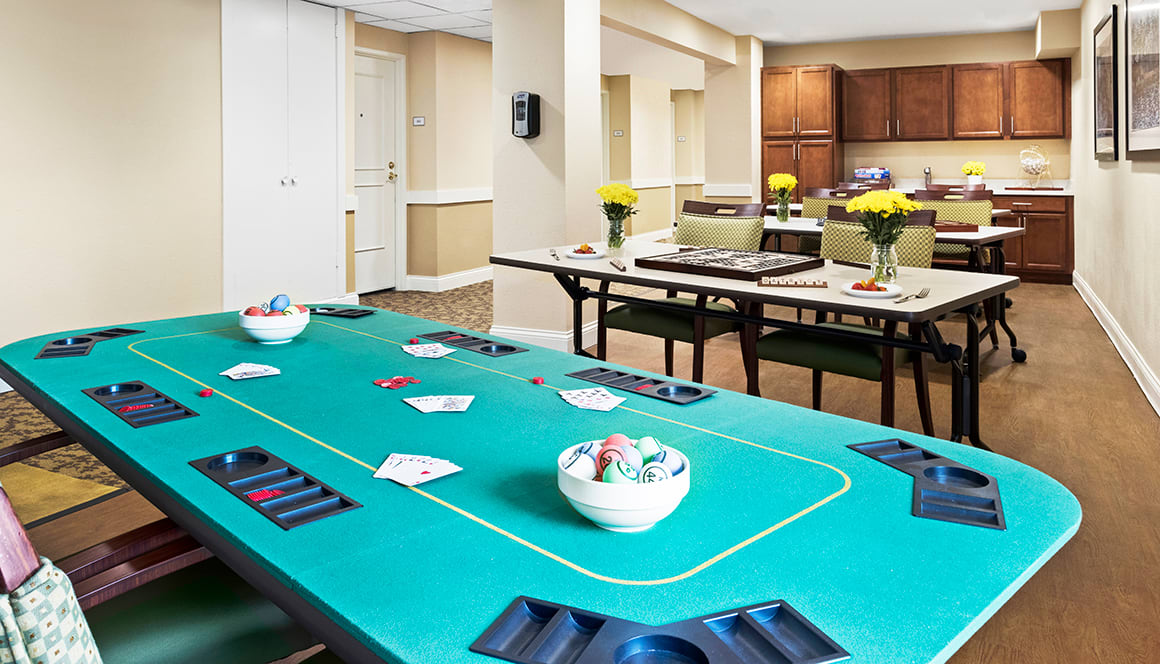 A well-equipped recreation room featuring a poker table with cards and chips ready for play.