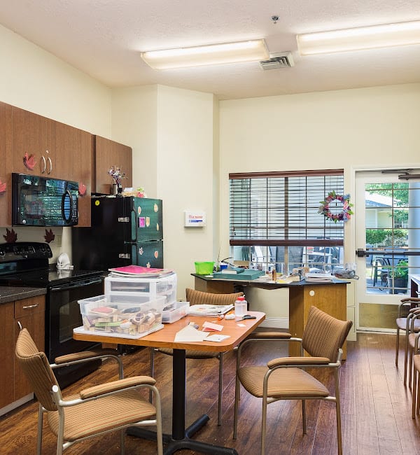 A communal kitchen and dining area with appliances and a table.