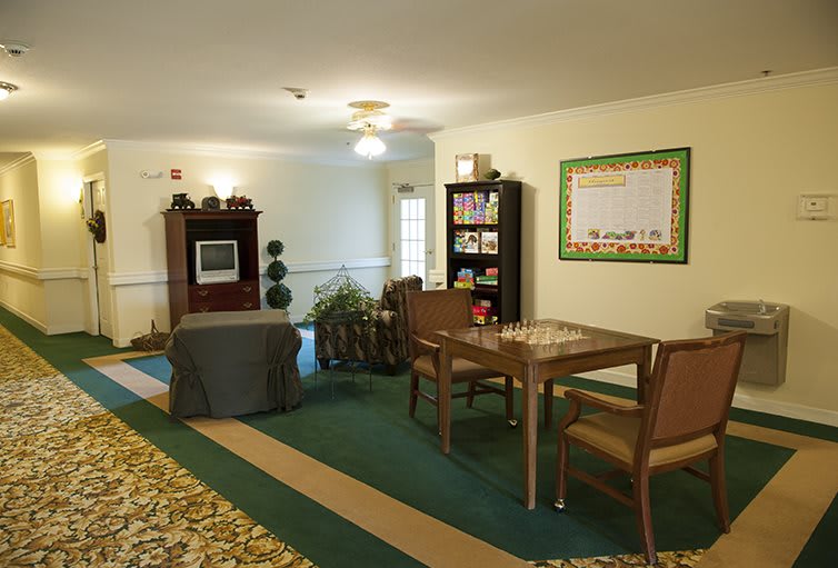 A cozy living room area with seating, a television, and a bookshelf.