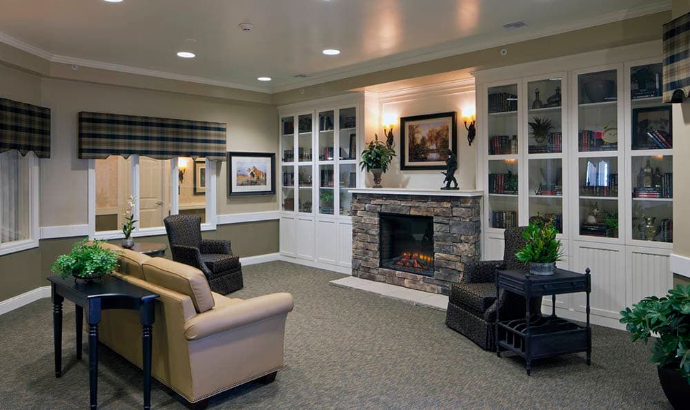A cozy living room featuring a stone fireplace and comfortable seating with modern decor.