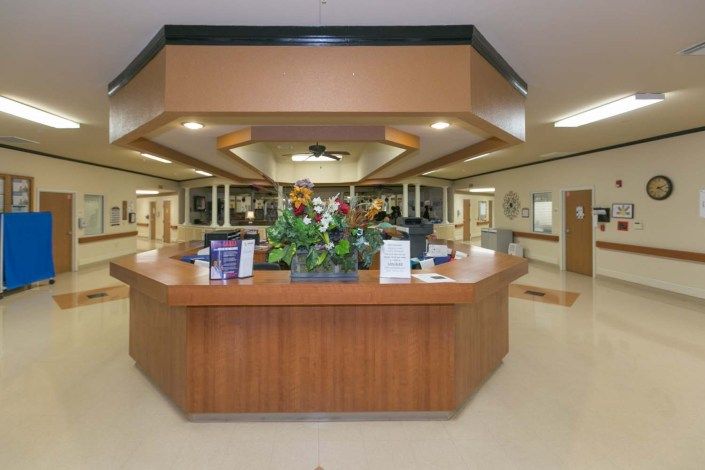 A hospital reception area featuring a central desk with floral decorations.