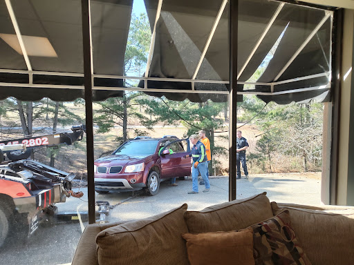 A cozy interior view looking out towards a red car and people interacting outside.