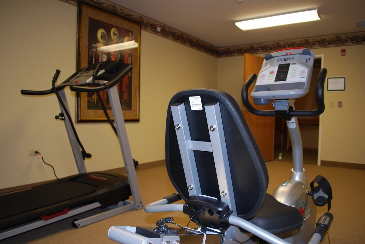 A small gym equipped with a treadmill and stationary bike.