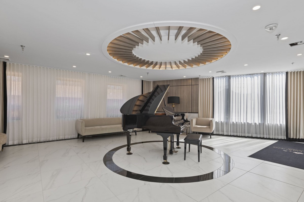 A modern and luxurious living room featuring a grand piano with elegant wooden ceiling decor.