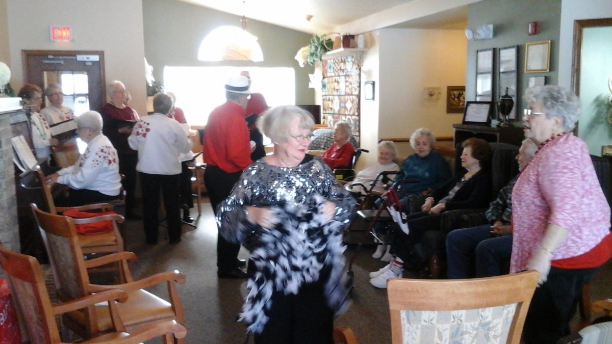 A lively social gathering with seniors enjoying music and dancing indoors.