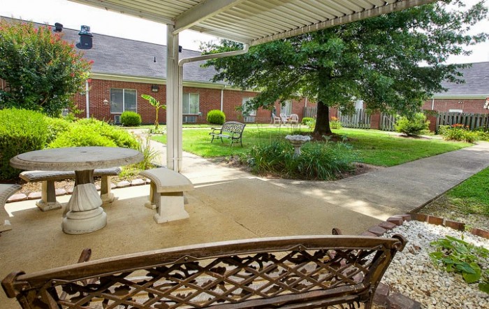 A peaceful patio with outdoor seating and lush greenery.