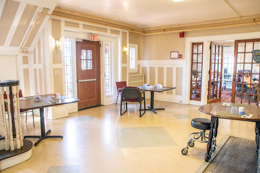 A well-lit lobby area featuring tables and chairs, designed for comfort and accessibility.