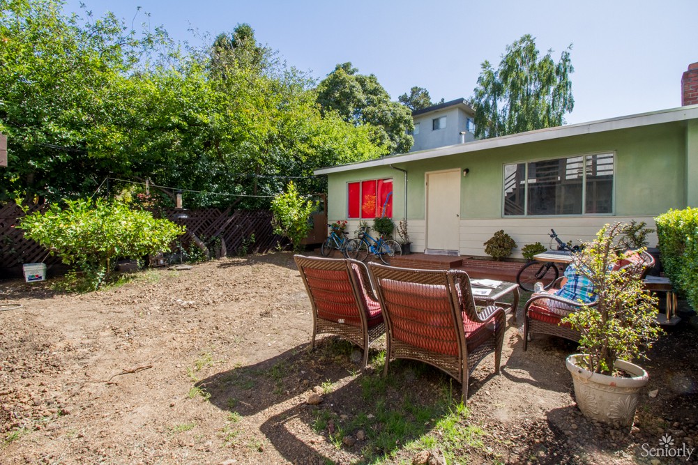 A cozy backyard with patio furniture set up on a sunny day.