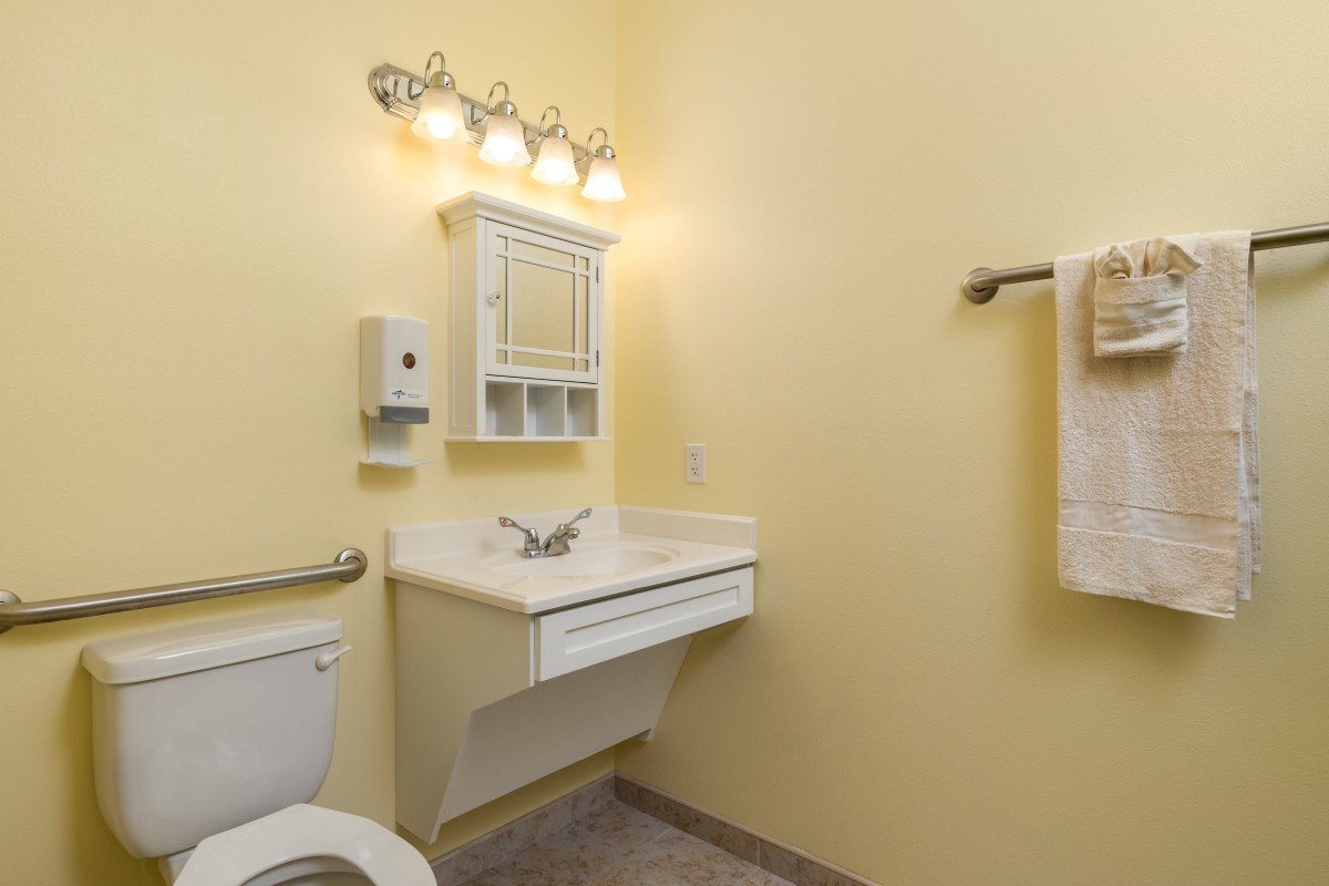 A clean and simple bathroom with a wall-mounted sink and cabinet.