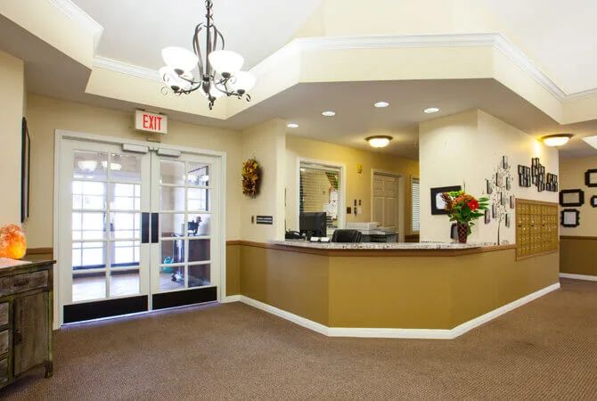 A welcoming reception area with a desk, decorative lighting, and entrance doors.
