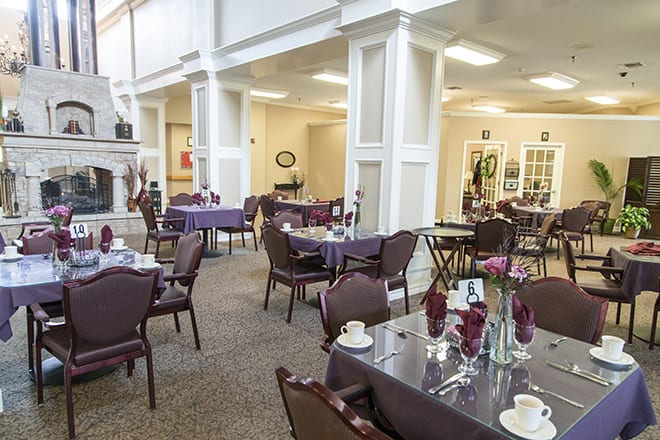 An elegant dining area with neatly arranged tables and floral decorations.