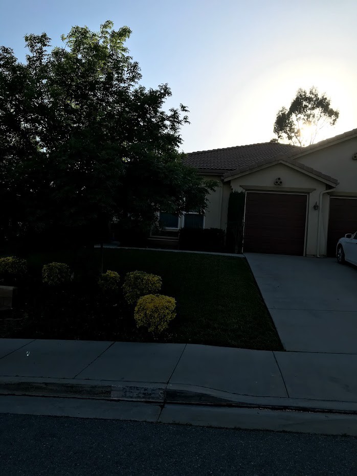A suburban house with a driveway, garage, and well-maintained lawn.