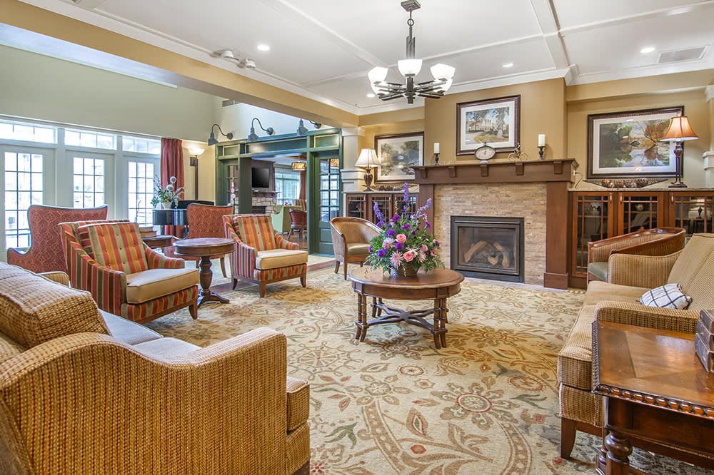 A cozy living room with elegant furniture arranged around a fireplace.