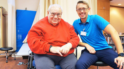 A joyful moment shared between an elderly man and his caregiver.