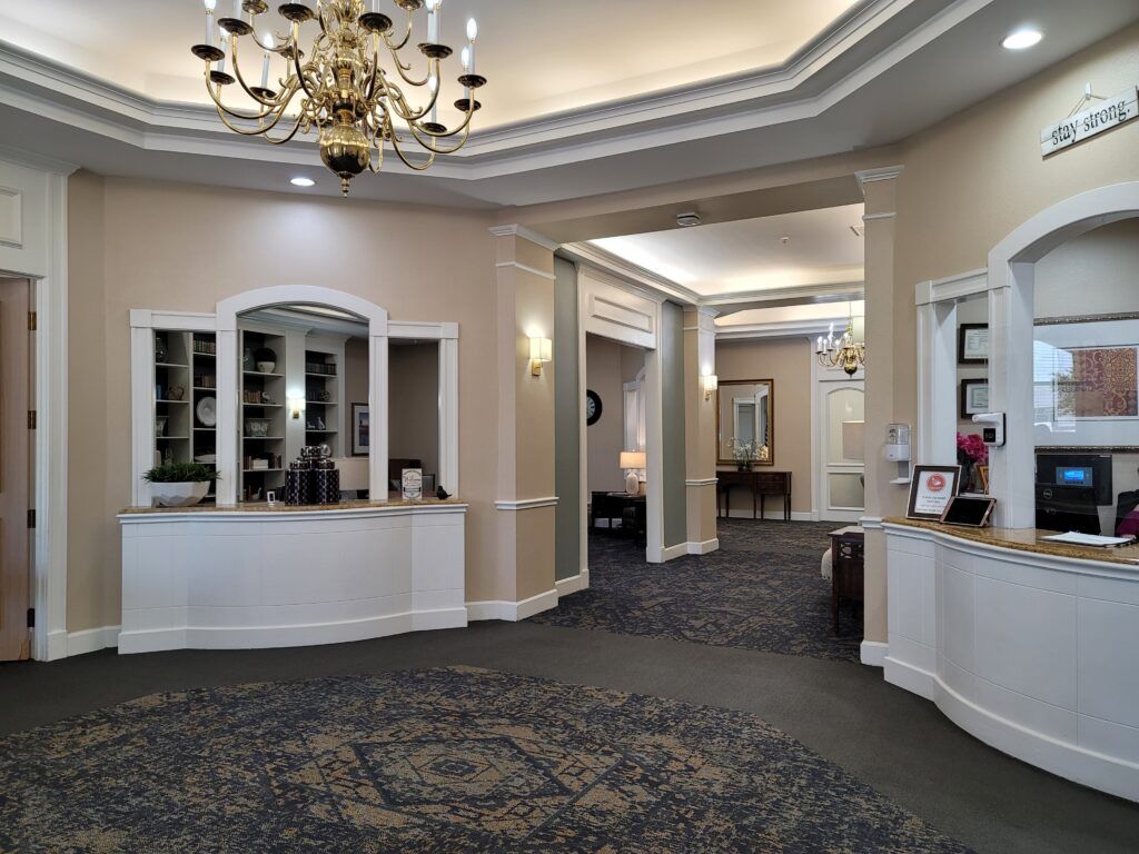 A spacious hotel lobby with a chandelier and reception desk.